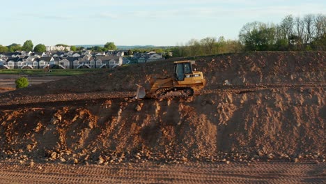 Bulldozer-Caterpillar-Retrocede-Montaña-De-Tierra,-Sitio-De-Excavación