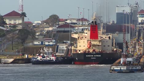 Tugboat-pushing-the-oil-tanker-in-the-right-position-at-Gatun-Locks,-Panama-Canal