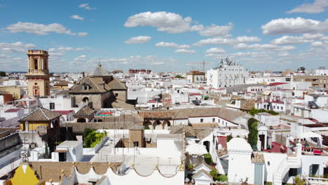 Vista-Aérea-Ascendente-De-La-Ciudad-De-Sevilla-De-Color-Blanco-Con-Edificios-Antiguos,-Iglesia-Y-Casco-Antiguo-Durante-El-Día-Soleado-En-Verano