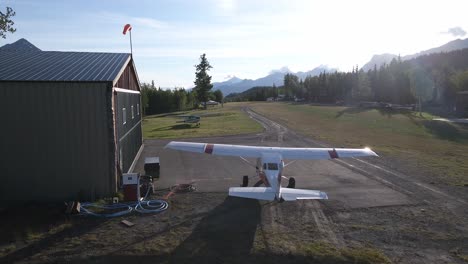 Langsam-über-Eine-Cessna-206-Neben-Einem-Hangar-über-Einer-Privaten-Graslandebahn-Fliegen