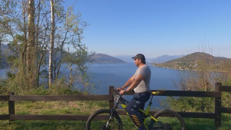 Fpv-of-man-on-bicycle-contemplating-beautiful-panoramic-view-over-Maggiore-lake