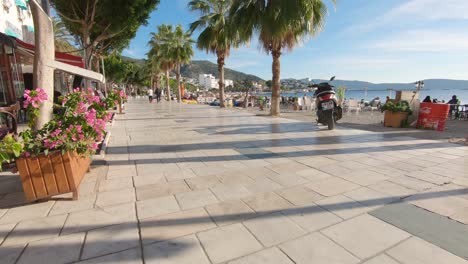 Dolly-En-Tiro-Inclinado-Que-Muestra-El-Hermoso-Y-Tranquilo-Paseo-Marítimo-De-La-Playa-De-Bodrum-En-Un-Día-Soleado-De-Verano