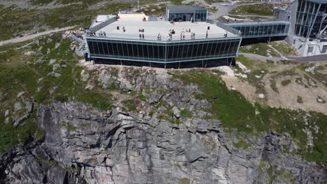 Espectacular-Edificio-Loen-Skylift-Cerca-De-La-Antena-Lejana-Inversa---Mirador-De-Techo-Lleno-De-Turistas-En-El-Soleado-Día-De-Verano---Ubicación-Peligrosa-En-El-Borde-Del-Acantilado---Montaña-Hoven-En-Loen-Noruega