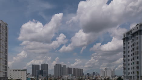 Time-lapse-of-dramatic-clouds-and-blue-sky-with-modern-urban-high-rise-apartment-buildings-on-sides-and-in-distance