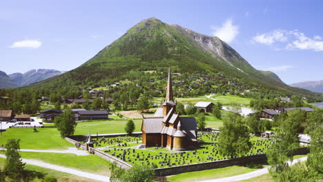 Luftaufnahme-Der-Stabkirche-Von-Lom-Mit-Grabstein-In-Der-Nähe-Der-Berge-Und-Des-Flusses-Otta-In-Norwegen