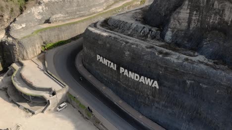 Aerial-view-of-road-between-cliffs-to-hidden-Pandawa-Beach-Bali-Island-Indonesia