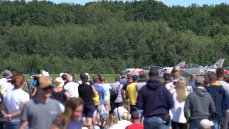 Crowd-looking-five-PZL-130-Orlik-airplanes-on-the-Aerobaltic-airshow-2021-taking-off-from-the-runway