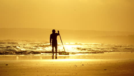 Silhouette-of-fisherman-catching-snails-and-seashells-on-Vietnam-coast-during-golden-sunset,-traditional-Vietnamese-livelihoods