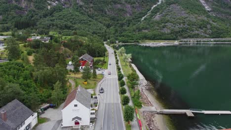 Norway-national-road-rv7-passing-through-Eidfjord-before-climbing-up-to-Harangervidda-mountain---Aerial-over-road-with-traffic-close-to-fjord---Eidfjord-Norway