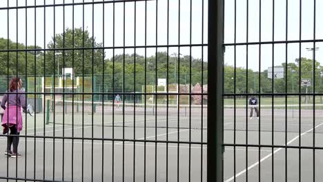 Zeitlupendame-übt-Tennis-Auf-Dem-öffentlichen-Spielplatz-Des-Vororts