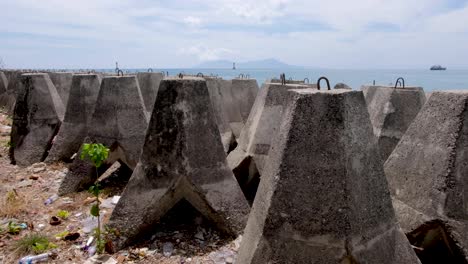 Artificial-shoreline-sea-wall-constructed-of-huge-concrete-blocks-for-coastal-defence-in-capital-Dili,-Timor-Leste,-Southeast-Asia