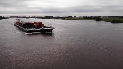 Luftaufnahme-Von-Zwei-Frachtcontainerschiffen-Und-Lastkähnen,-Die-Entlang-Des-Flusses-Oude-Maas-Fahren