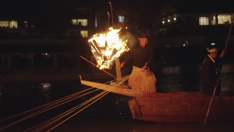 Maestro-De-Pesca-Ukai-Sujetando-Cuerdas-Atadas-A-Cormoranes-Por-La-Noche