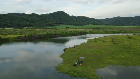 Aerial-footage-towards-as-gorgeous-landscape,-mountains,-farmlands,-people-fishing,-a-white-USV,-people-having-picnic,-Saraburi,-Muak-Klek,-Thailand