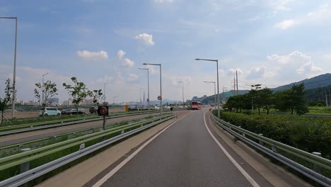 Cars-moving-along-the-expressway-Gangbyeonbuk-ro-road-near-Han-river,-Lotte-tower-on-background-Seoul,-Korea,-Jun-27,-2021