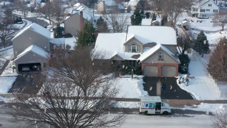 Ein-US-Briefträger-Liefert-Ein-Weihnachtspaket-Mit-Schnee-Bedeckt-Nach-Hause
