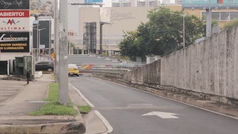Rückansicht-Eines-Gelben-Taxis,-Das-Langsam-Eine-Ruhige-Stadtstraße-Hinunterfährt,-Am-Ende-Der-Straße-Abbiegt,-Abbiegt-Und-Außer-Sichtweite-Fährt,-Panama-City