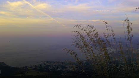 Breathtaking-sideways-panoramic-view-of-Sicilian-coastline-with-Monte-Cofano-in-background-at-sunset,-Sicily-in-Italy