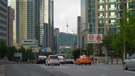 Vehículos-Que-Viajan-En-La-Carretera-En-Medio-Del-Paisaje-Urbano-Del-Distrito-De-Yongsan-En-Seúl,-Corea-Del-Sur