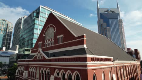 aerial-push-into-the-ryman-auditorium-with-skyscrapers-in-background-in-nashville-tennessee