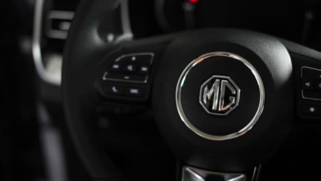 black-modern-car-steering-wheel-with-lighted-display-and-morris-garages-logo
