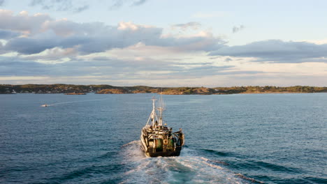 Luftaufnahme-Eines-Kommerziellen-Fischerbootes,-Das-Nach-Dem-Fischfang-Im-Meer-In-Norwegen-Nach-Hause-Fährt