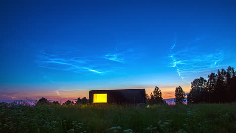 Cabin-During-Sunset-And-Blue-Hour-From-A-Countryside-Meadow-With-Flowers