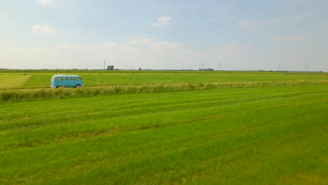 Low-aerial-view-approaching-VW-van-driving-through-countryside