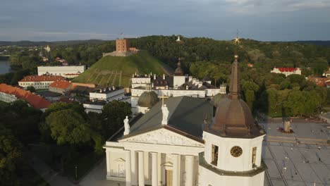 AERIAL:-Flying-Close-By-Vilnius-Cathedral-and-Bell-Tower-in-Summer-with-Gediminas-Hill-in-Background