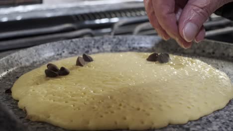 Hermosa-Mano-Coloca-Chispas-De-Chocolate-En-Panqueques,-Desayuno-De-Hotcakes,-Cerrar