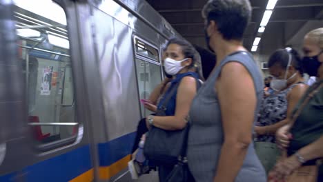 Passengers-wearing-face-masks-boarding-the-metro-train-while-wearing-face-masks