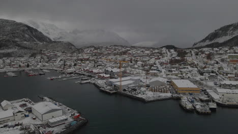 Vista-Aérea-Del-Puerto-De-La-Pequeña-Ciudad-De-Skjervoy-En-Un-Día-Nublado-De-Invierno-En-El-Condado-De-Troms,-Noruega---Disparo-De-Drones