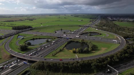 Large-Oudenrijn-bypass-intersection-roundabout-near-Utrecht-with-traffic-jam-seen-from-above-with-cumulus-clouds-hanging-over-it-and-slow-transit