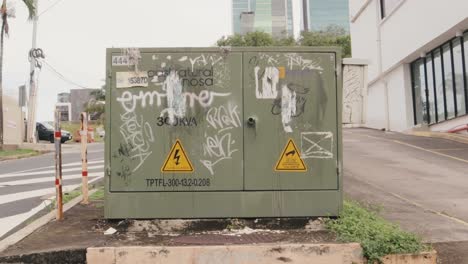 Static-shot-of-a-green-electrical-transformer-box,-vandalised-with-spray-painted-graffiti-from-the-local-rebellious-urban-movements,-Panama-City