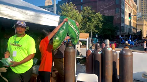 Chica-Del-Personal-Del-Evento-De-Picklesburgh-Llenando-El-Aire-En-El-Globo-Verde-De-Picklesburgh