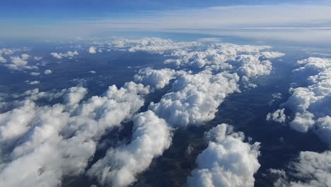 Flying-over-islands-of-beautiful-clouds-over-a-mountain-landscape--Aerial