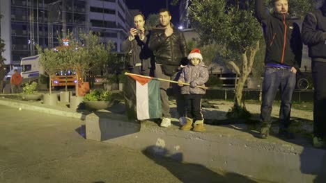 Ein-Kind-Hält-Eine-Palästina-Flagge-Während-Einer-Demonstration-Für-Flüchtlingsrechte-In-Den-Straßen-Von-Athen,-Griechenland