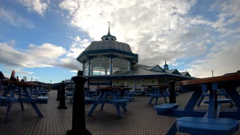Wolken-Ziehen-über-Llandudno-Pier,-Pavillon,-Hölzernes-Viktorianisches-Walisisches-Wahrzeichen,-Café,-Zeitraffer,-Langsam-Links
