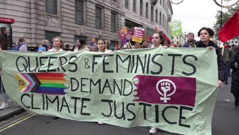 Demonstranten-Mit-Einem-Banner-Mit-Der-Aufschrift-„Queers-Und-Feministinnen-Fordern-Klimagerechtigkeit“-Marschieren-Mit-Tausenden-Zum-Globalen-Tag-Der-Klimagerechtigkeit,-Während-In-Glasgow-Der-Cop-26-Gipfel-Stattfindet