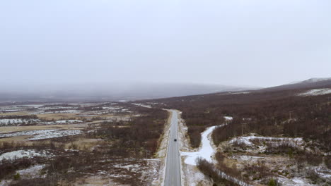 Vista-Aérea-De-La-Carretera-Nacional-Con-Montañas-Neblinosas-En-El-Fondo-En-Dovre,-Noruega