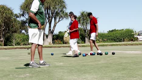 An-elderly-man-bowls-from-the-mat-in-a-lawn-bowls-competition