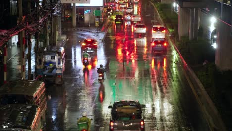 Raining-over-traffic-through-busy-intersections-at-rush-hour-in-Bangkok-which-is-controlled-by-traffic-lights,-there-is-heavy-traffic-every-day