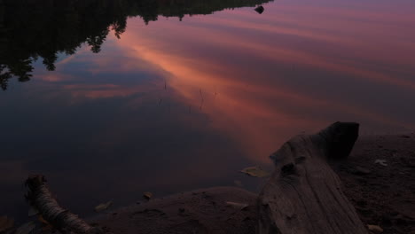 Magic-hour-with-the-forest-and-colourful-evening-sky-mirrored-on-a-smooth-lake-surface