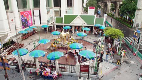 Blick-Auf-Den-Hinduistischen-Schrein-Vom-BTS-Skytrain-Und-Thailändische-Und-Ausländische-Menschen,-Die-Thao-Maha-Phrom-Oder-Lord-Brahma-Great-Am-Erawan-Schrein-In-Bangkok,-Thailand,-Beten