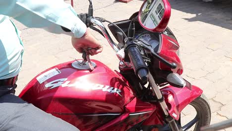 Petrol-pump-employee-fills-up-petrol-in-a-motorcycle-during-the-Covid-Pandemic-lockdown