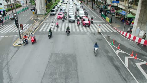 Traffic-through-busy-intersections-at-rush-hour-in-Bangkok-which-is-controlled-by-traffic-lights,-there-is-heavy-traffic-every-day