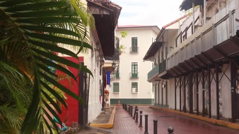 A-reveal-shot-of-a-cobblestone-street-and-the-old-Hispanic-architecture-of-the-surrounding-buildings,-rebellious-urban-youths-having-defaced-the-walls-with-graffiti,-Casco-Viejo,-Panama-City