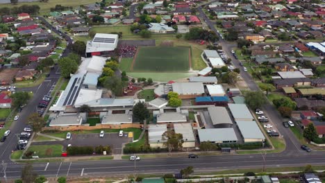 AERIAL-Over-Primary-Elementary-School,-Students-Gather-Near-Gymnasium