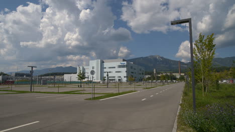 Weitwinkelaufnahme-Eines-Leeren-Parkplatzes-Auf-Einer-Biogen-Fabrik-In-Der-Schweiz-An-Einem-Sonnigen-Tag---Forschung-Zu-Moderner-Medizin,-Neurowissenschaften,-Alzheimer-Krankheit,-Multipler-Sklerose-Und-Parkinson