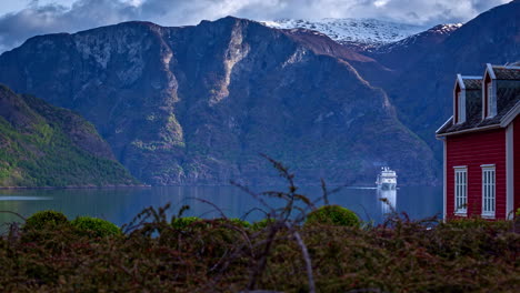 Time-lapse-shot-of-Cruise-Ship-entering-Fjord-in-Norway-during-cloudy-day---Beautiful-mountain-landscape-with-snowy-peak